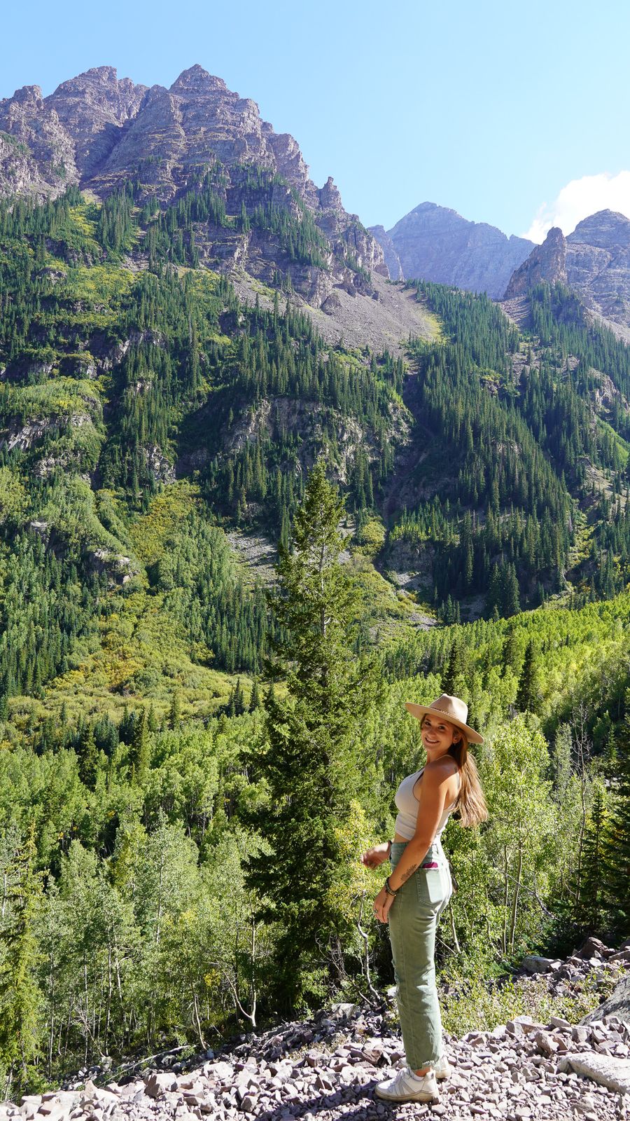 Chelsea hiking a forest trail below the Maroon Bells